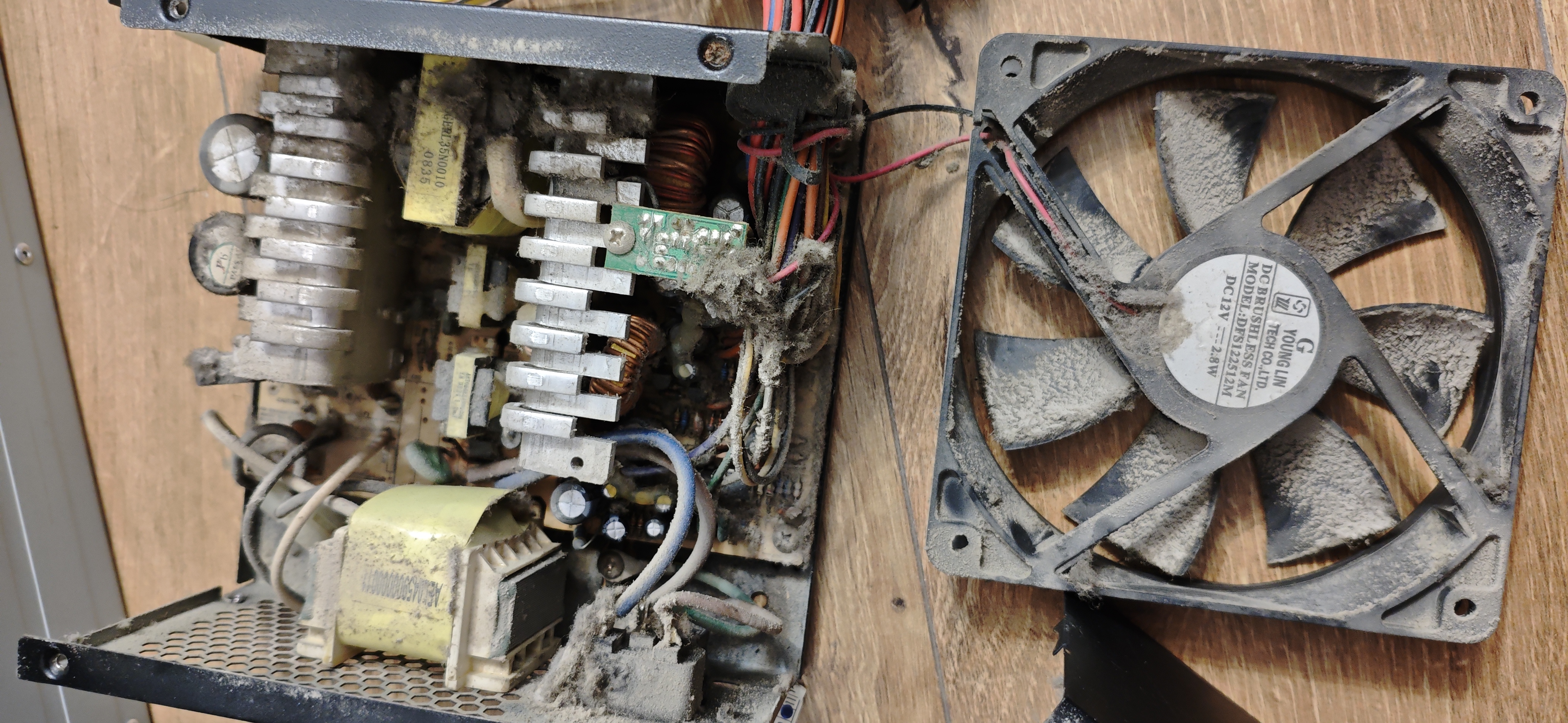 Sursă PC și ventilator cu acumulări vizibile de praf, înainte de curățare